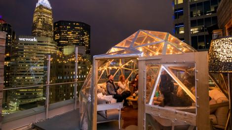 Enjoying a rooftop happy hour with views of downtown Charlotte at Merchant & Trade in Charlotte, North Carolina