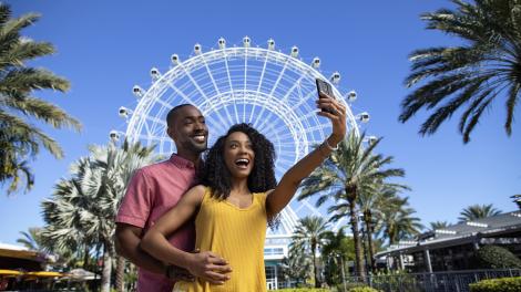 Couple posing in front of the Wheel at ICON Park in Orlando, Florida