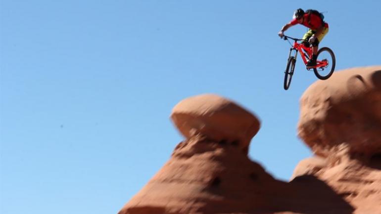Eric Porter, professionnel du vélo de montagne, sautant d’une falaise à côté de Moab, dans l’Utah