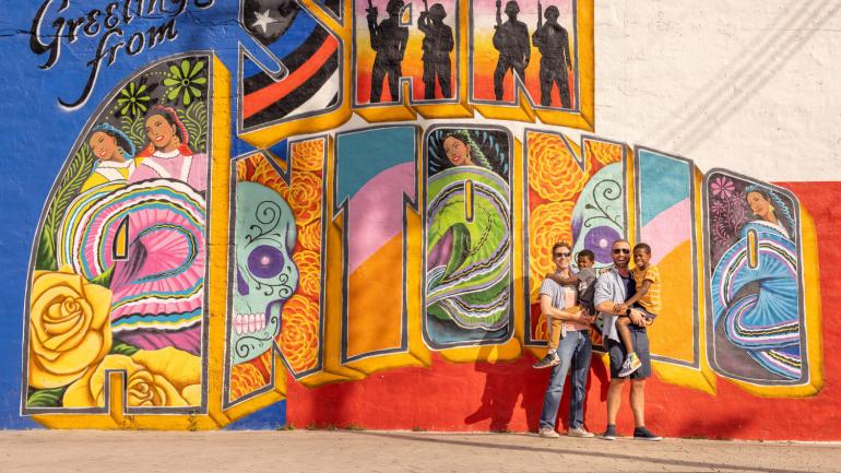 Une famille pose devant une peinture murale colorée à San Antonio, Texas