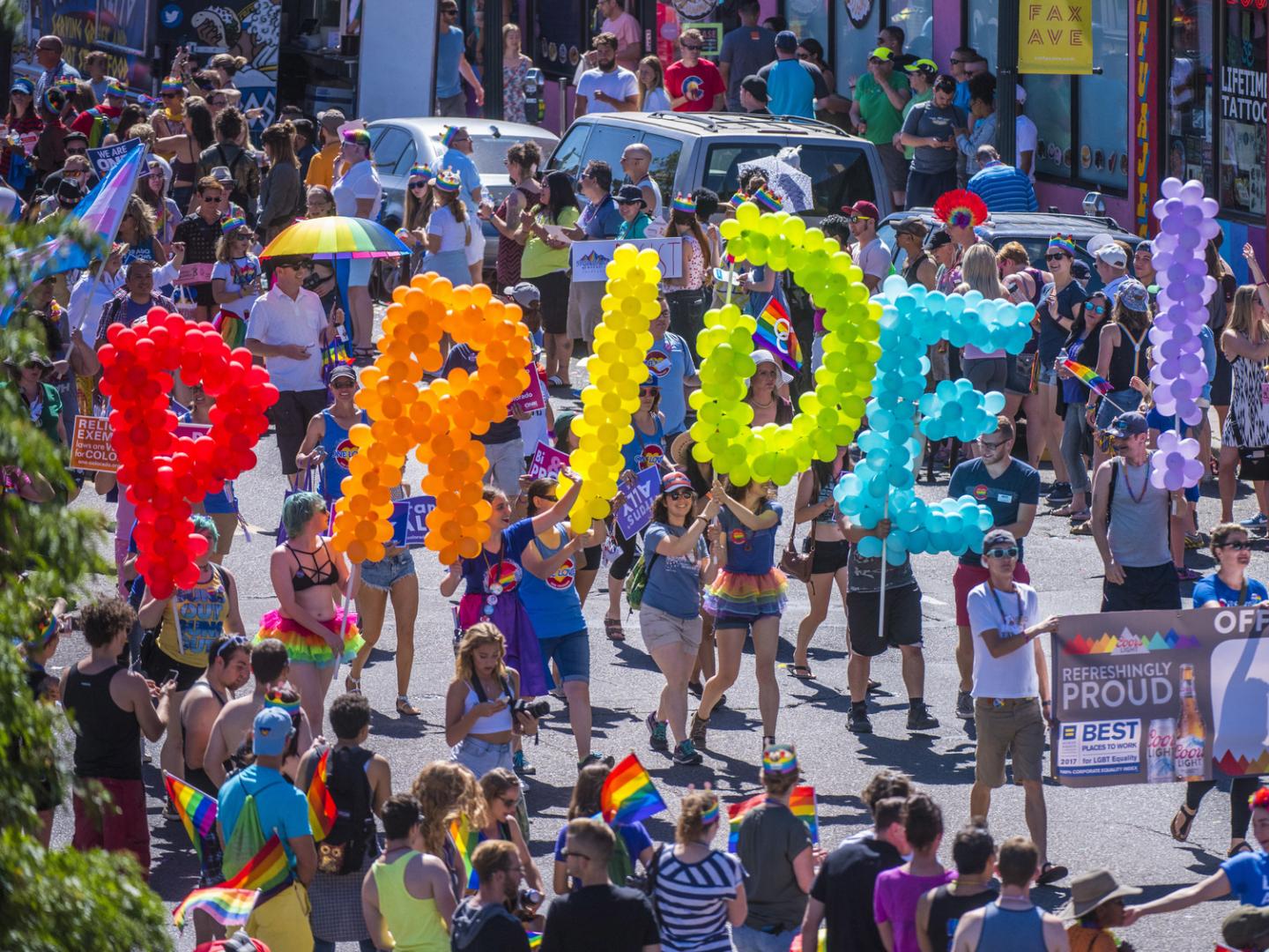 Revelers carry colorful balloons during the Denver Pridefest parada