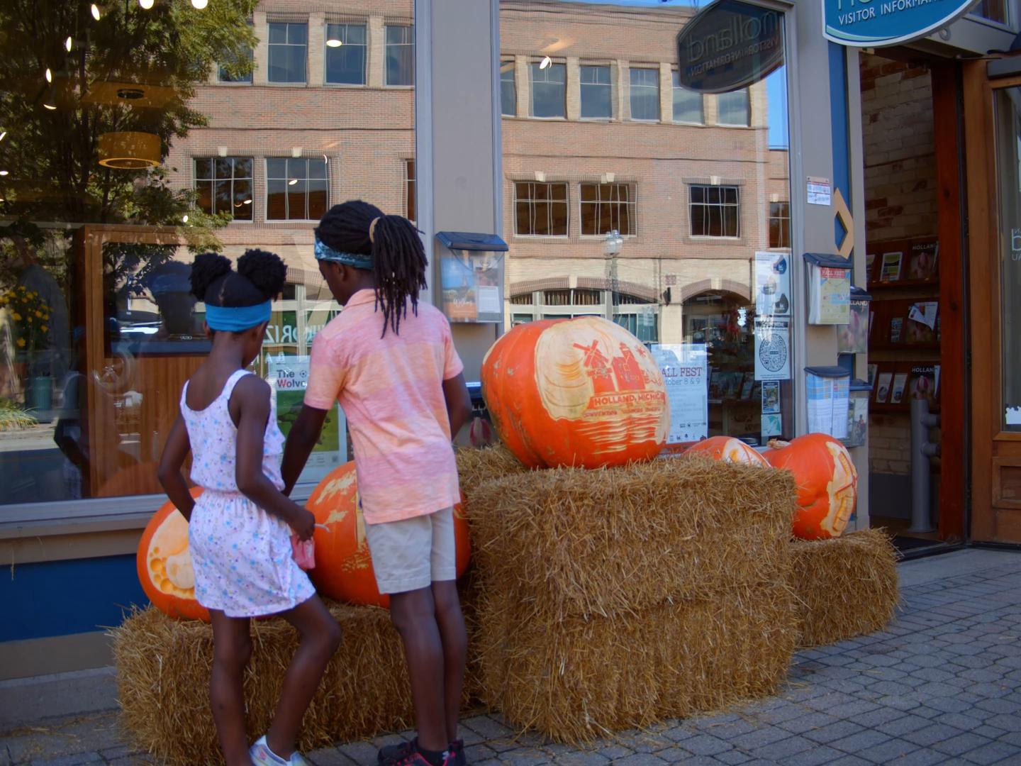Niños viendo calabazas talladas en el centro de Holland, Michigan, durante el Fall Fest