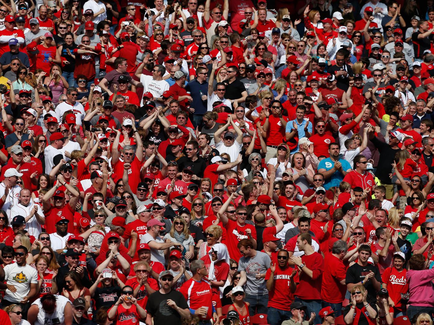 Un gran grupo de fanáticos de Cincinnati animando en una nueva temporada de béisbol de los Reds en Cincinnati, Ohio