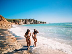 ビエケス島の黒砂のビーチをそぞろ歩く人