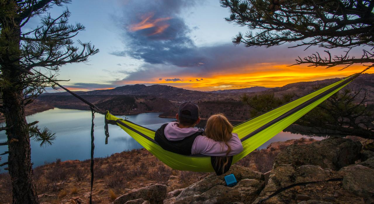 Couple admirant le rougeoiement du coucher de soleil dans un hamac avec vue sur Horsetooth Reservoir