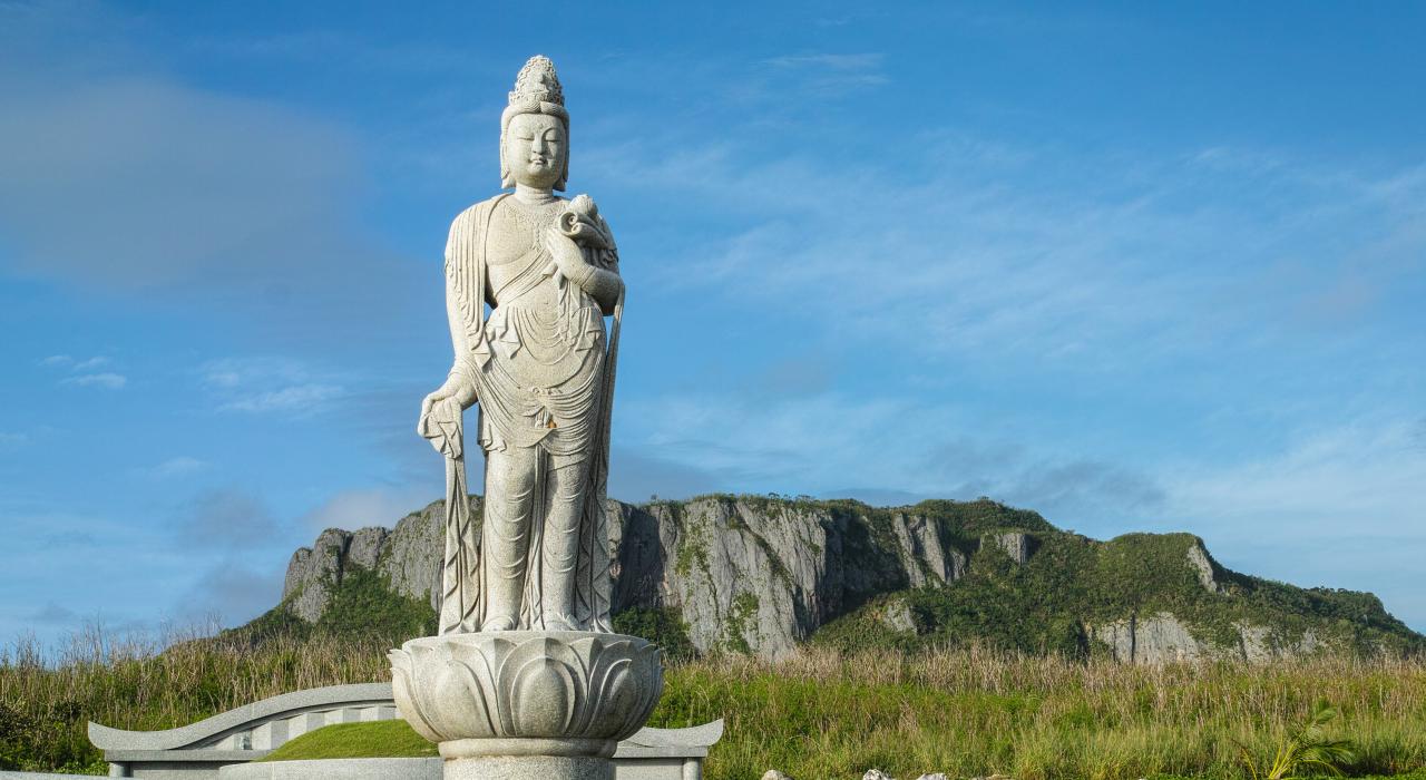 万岁崖纪念公园的日本纪念雕塑和背景中的自杀崖