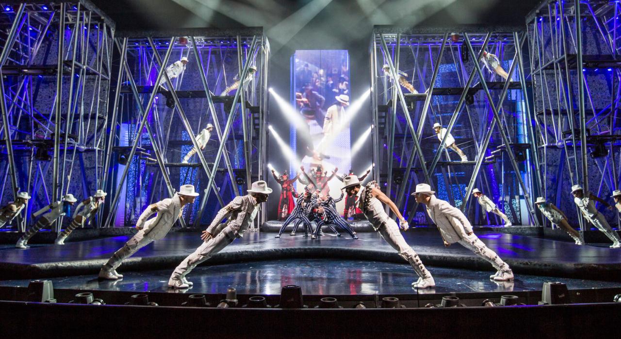 Os ginastas de Smooth Criminals duelam contra os MJ Warriors, grupo de dança de Michael, até culminar no incrível momento da coreografia inclinada vista em “Smooth Criminal”.