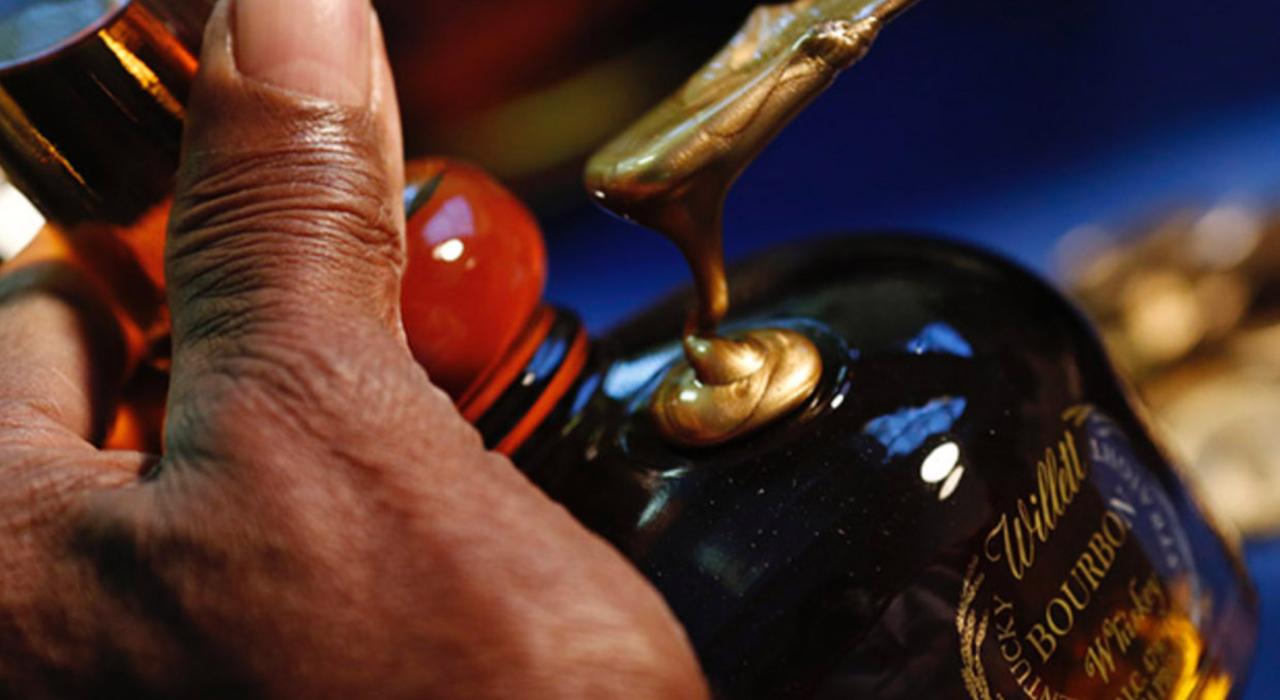 Putting the finishing touches on a bottle of Willett whiskey