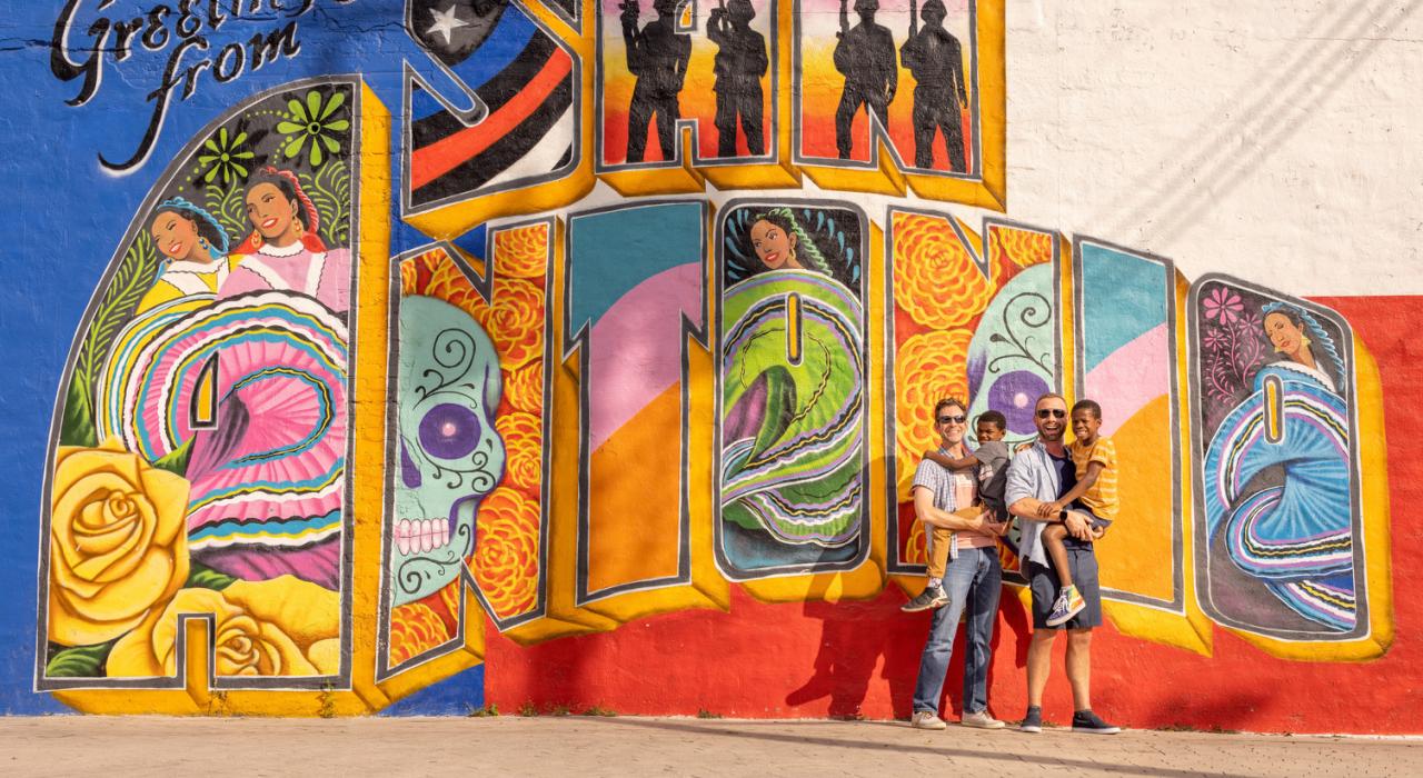 Une famille pose devant une peinture murale colorée à San Antonio, Texas